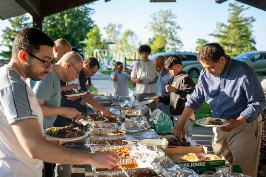 Community members filling their plates at the MAS Family Potluck